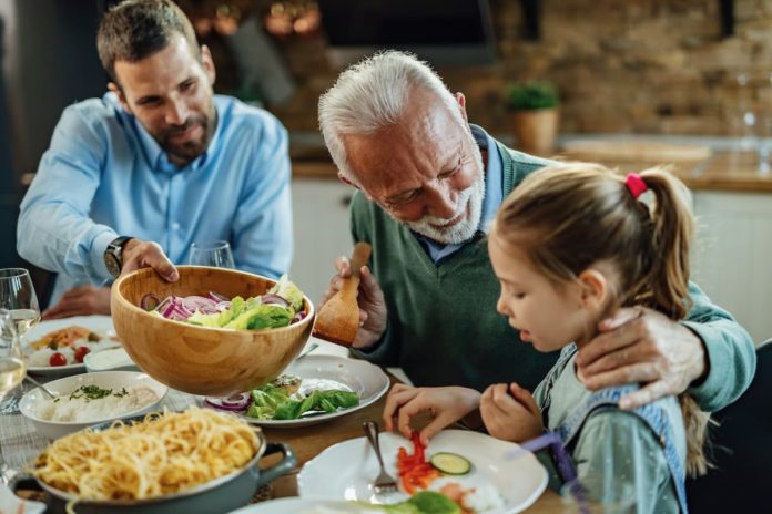 anciano feliz hablando su nieta mientras almorzaba mesa comedor 1